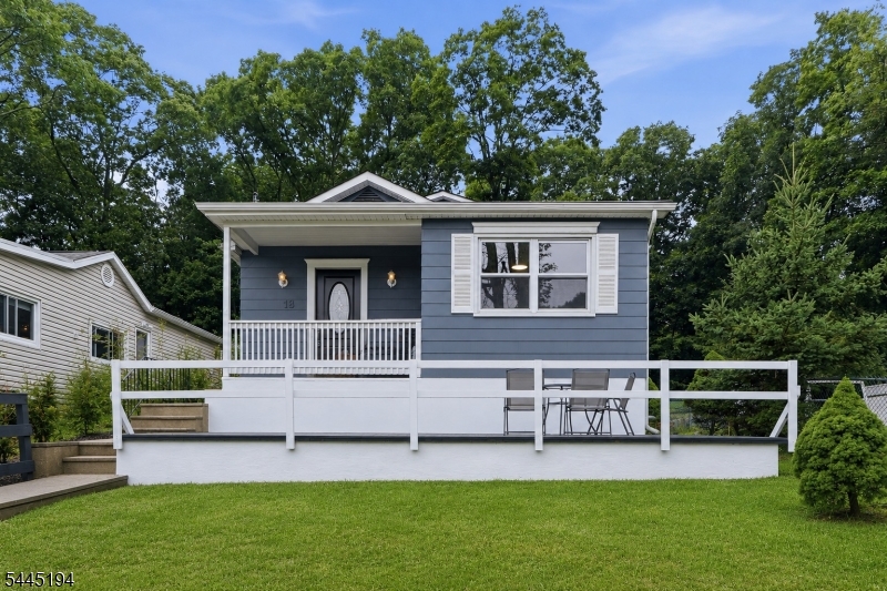 Tucked into one of Hopatcong's lake-area neighborhoods, 18 Coolidge Trail offers the kind of everyday lifestyle that makes coming home feel easy. Start your mornings with coffee in the bright open living space, gather around the oversized kitchen island and enjoy a layout that keeps everyone connected without sacrificing privacy. The heart of the home is the renovated kitchen, featuring granite counters, stainless steel appliances, abundant cabinetry, recessed lighting, and a seamless flow into the dining and living areas, ideal for quiet nights in, weekend entertaining and the natural rhythm of daily life. The main level offers a bedroom and full bathroom, creating valuable flexibility for guests, work-from-home needs, or convenient first-floor living. Upstairs, two additional bedrooms each enjoy the comfort of nearby full baths, including a private primary suite with its own full bathroom for a true retreat at the end of the day. Hardwood flooring, neutral finishes, generous natural light, and thoughtful updates give the home a warm, move-in ready feel throughout. Outside, the slate patio and wooded rear yard extend the living space into nature, perfect for summer dinners, morning air, or unwinding after a day on the lake. Set near Lake Hopatcong's beloved boating, marinas, restaurants, parks, and year-round recreation, this home offers more than just updated space; it offers a lifestyle rooted in comfort, convenience, and the relaxed energy of lake-community living.