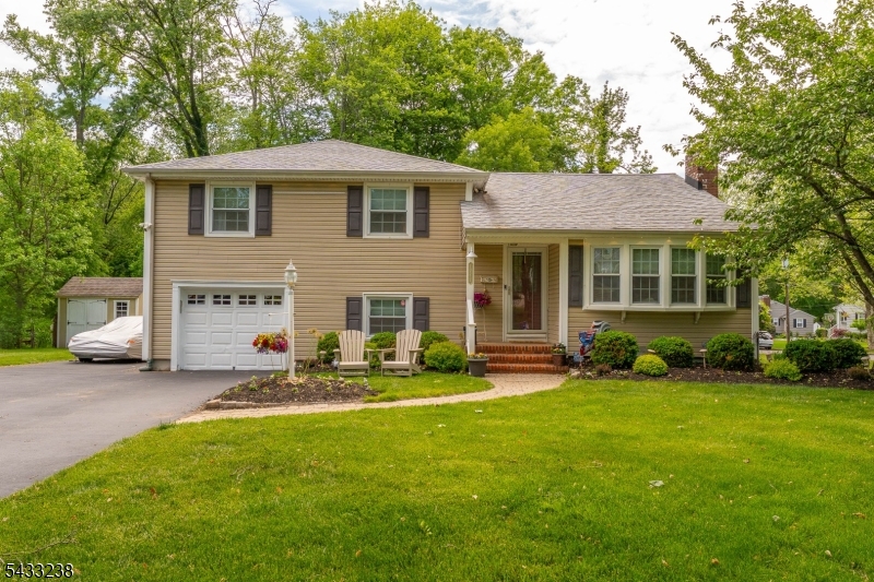 As you approach this move-in ready split-level home on a well-maintained corner lot, you are greeted by lush landscaping, mature trees, and a long driveway leading to the attached garage. Updated in 2023, the first level features a family room that flows into a four-season room with floor-to-ceiling windows and views of the sunlit backyard, along with a half bathroom. As you make your way to the main level, the living room welcomes you with hardwood floors, a picture window, and a fireplace. The updated kitchen offers bright cabinetry, spacious countertops, a center island, that is anchored by a sliding glass door leading to the rear deck. The third level is home to the private bedroom quarters, where you will find the primary bedroom complete with a half bathroom, two additional well-sized bedrooms, and a full bathroom. The finished basement provides a home office, gym space, built-in cabinetry, and laundry area. Outside you'll discover the true showpiece of this property: a backyard retreat featuring a large paver patio with dedicated dining and lounge areas, string lighting overhead, a rear deck off the kitchen, and a lush fenced-in yard with a storage shed and mature tree coverage that provides both privacy and shade.