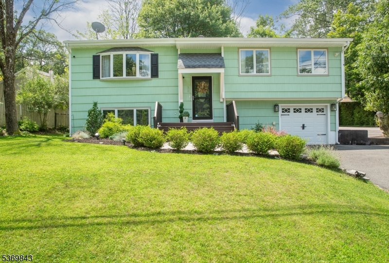 Located in the heart of Hopatcong on a quiet residential street, this meticulously maintained 4-bedroom, 1 full and 2 half bath Bi-Level home offers the perfect blend of comfort, style, and functionality. With impeccable curb appeal and lush landscaping, pride of ownership radiates from every corner of this property. Step inside to discover a sunlit open-concept living and dining space with warm hardwood floors, recessed lighting, and large windows that fill the home with natural light. The updated kitchen features crisp white cabinetry, granite countertops, stainless steel appliances, beverage fridge, and a breakfast bar that opens seamlessly into the dining area ideal for hosting and everyday living. From there, step outside to your private deck overlooking a peaceful, level backyard surrounded by trees your own personal retreat. On the second level, you'll find three spacious bedrooms and a beautifully remodeled full bathroom with custom vanity, modern finishes, and wainscoting detail. The lower level offers a fourth bedroom, a cozy second living area with designer touches, an additional half bath, and walk-out access to the backyard. Additional features include central air, a one-car garage, an oversized driveway, and tasteful updates throughout.