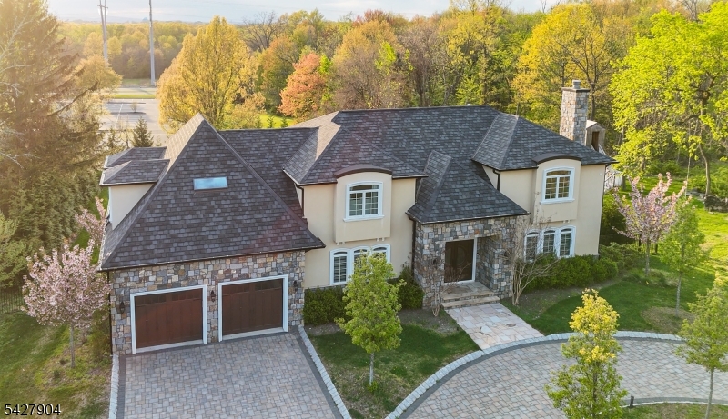 Located in the Riker Hill section of Livingston, this custom-built residence offers a well-designed layout with a range of interior and exterior amenities. The home features 7 bedroom, 5 full bathrooms, and 2 half bathrooms, with high ceilings and an open floor plan that supports both everyday living and entertaining. The kitchen is equipped with premium appliances and ample workspace. Outdoor amenities include a pool, jacuzzi, waterfall feature, terraced outdoor areas, and a designated BBQ and seating space. Interior features include a private movie theater, home gym, whole-house generator, and water filtration system. Additional features include a 2-car garage and a paver driveway with additional parking. The property is conveniently located near schools, public transportations to NYC, parks, and shopping. This residence presents an opportunity to own a home with a comprehensive set of amenities in a well-established Livingston neighborhood.