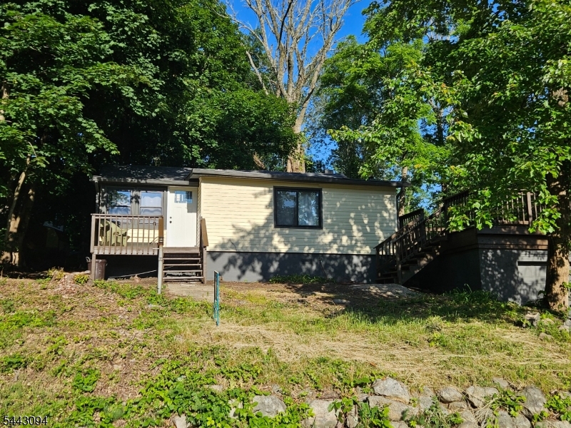 Welcome to the updated residence at 43 E Shore Trail in Hardyston, NJ, where modern comfort meets the natural beauty of lake-community living. Set on a spacious lot and framed by nature, this inviting home offers a peaceful lifestyle with a wonderful balance of indoor and outdoor enjoyment. The large deck is a true highlight, offering scenic views over the picturesque lake and creating the perfect setting for morning coffee, outdoor dining, entertaining, or quiet relaxation. The nearby lake recreation and beach area adds even more appeal, offering opportunities for seasonal enjoyment, outdoor activities, and the relaxed charm of a serene community setting. Inside, this humble abode features 2 Beds, a comfortable living room, dining area, updated kitchen, storage space, wood-burning stove, deck, and garage. The living room serves as the heart of the home, with flexible space for a variety of layouts. The wood-burning stove adds warmth, character, and a cozy focal point. The kitchen is ready to serve with modern appliances and thoughtful storage solutions. Recent renovations provide a fresh, comfortable, and contemporary feel while preserving the charm expected in a lake-area retreat. 43 E Shore Trail awaits those seeking a fresh start in a home that fuses modern convenience, natural splendor, lake views, and beach-community amenities. Schedule your private viewing, we will meet you at the front door!