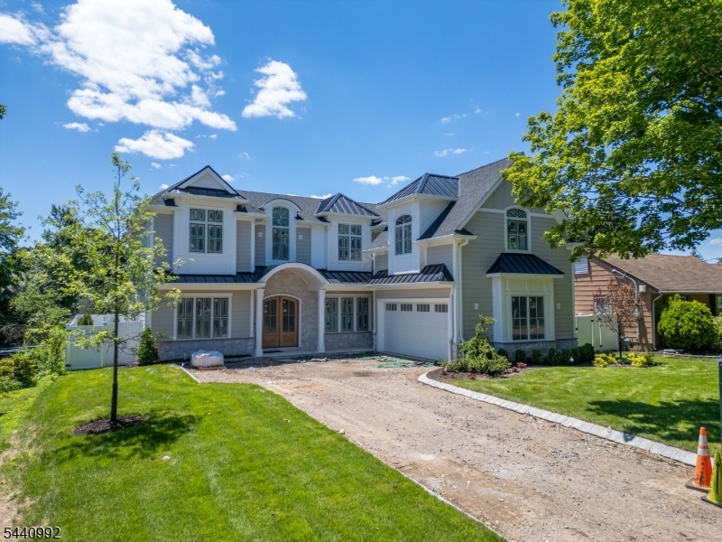 Experience luxury living in this stunning custom Colonial offering approximately 7,500 square feet of finished living space, including a 2,500 square foot finished basement. A grand two-story foyer with a sweeping staircase welcomes you into a home featuring a dramatic two-story family room with gas fireplace, gourmet chef's kitchen with dual islands, Wolf and Sub-Zero appliances, and exceptional custom finishes throughout. The lower level is designed for entertaining with a movie theater, fitness center, en-suite bedroom, and wet bar. The second floor offers four spacious bedroom suites, each with a private bath, plus a convenient laundry room. A third-floor bonus room provides additional flexible living space. Situated on a 0.28-acre lot, this exceptional residence features 13 rooms, 6 bedrooms, and 6.5 baths in one of Bergen County's most desirable locations.