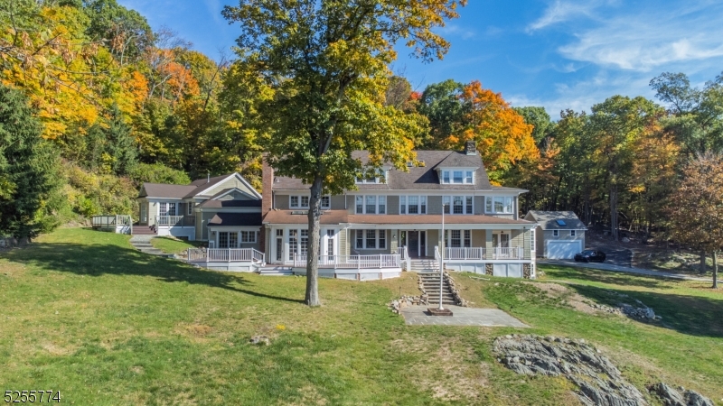 A once-in-a-lifetime estate in Kinnelon and Montville with stunning views of your own private 25-acre lake Surprise Lake. Just 30 miles from NYC and under 5 miles from a private airport, this iconic property offers unmatched privacy, charm, and accessibility. The updated main house spans 3 levels and features a modern kitchen, refinished hardwood floors, a game room above the garage, and a new bar on the lower level. There are 4 bedrooms on the second floor and 2 more on the third, including a lake-facing primary suite with breathtaking views year-round. Also included: a renovated carriage house with garage and studio apartment above, a boathouse, and a 2-bedroom home currently rented for $2,700/month. The original Boy Scout mess hall has been restored with new roof and windows and is ready for your custom finishes (Think guest house, workout studio, or the ultimate car collectors garage, to name a few). Direct access to hiking trails, close to top restaurants and shopping, and featured in movies, TV shows, and commercials, this remarkable property is truly one of a kind. (Comprising  of five separate lots, taxes reflect the total for all five)