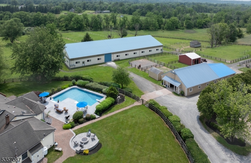 Thoughtfully designed with attention to detail, this equestrian facility can accommodate all degrees of professionalism. This beautiful turn key facility is sited on almost 11 acres nestled in 'the valley' which is home to the Amwell Valley Hounds Hunt and Amwell Valley Trail System! A long tree lined private drive brings you to a private oasis featuring a cottage style home which has been updated to today's standards. A wonderful country kitchen, which is the heart of the home, features walls of windows overlooking the salt water pool & farm! Open floor plan with high ceiling family room with fireplace. Formal dining & living rooms provide a cozy contrast. Primary suite opens to deck & pool. Two other generous bedrooms are serviced by a full updated bath. The utility wing has powder room, laundry & ample closet storage. The center aisle barn has 10 box stalls, hot & cold water, wash stall, tack & feed room & full loft, Wifi, fire alarm system & blue tooth capabilities for sound system. A bright and airy 180'x80' indoor arena features GGT footing, LED lighting, sound system, heated viewing room. There is an outdoor arena 200'x80' with sand footing & gazebo for viewing opportunities. A European hot walker is tucked away with easy accessibility to paddocks & lush fields which have automatic waterers. Located near "all things equestrian", top vets, easy access to NJ & PA HORSE PARKS, POLO, Horse shows, Fox hunting, trails, hunter paces, tack and feed shops.