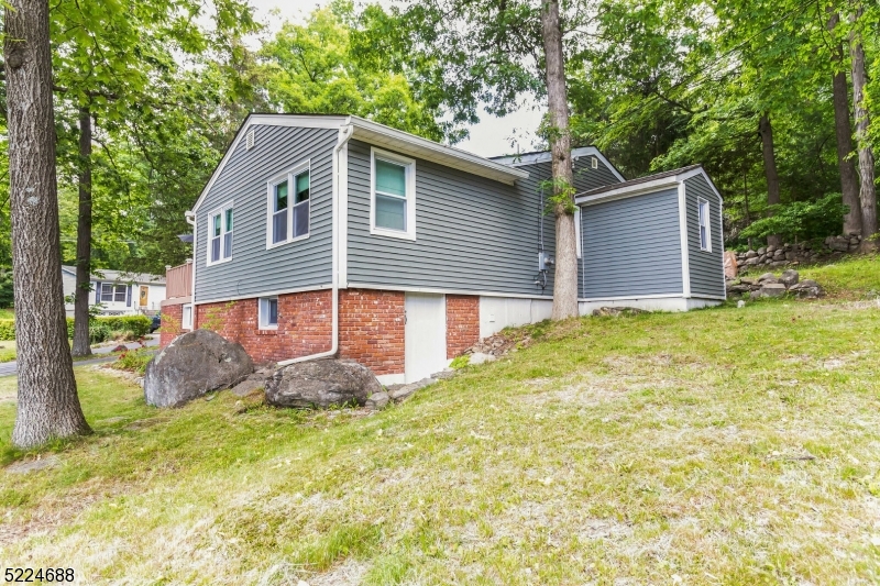 Welcome to beautiful Scenic Lakes! Conveniently located off route 23. Indulge in the tranquility of this charming neighborhood with a wonderful lake view and very close to the beach. renovated in 2019 this open-concept, corner lot ranch is situated on nearly a 1/4 acre of land and features high ceilings, recessed lighting, and a cozy wood-burning fireplace. Create lasting memories with friends and loved ones around the breakfast bar or dine in the generous dining area. The expansive modern kitchen is equipped with SS appliances, ample counterspace, and two spacious pantries. The heating and cooling, ductless mini-split system supports eco-conscious living and cost savings that reduces the reliance on fuel oil. The lake-facing primary bedroom is full of natural light and the ensuite boasts a beautiful walk-in shower. Enjoy the natural beauty of the outdoors on either the private patio or the lake-facing deck. The lower level of the home is accessible from outside and contains the oil tank, water heater, well equipment, as well as an additional area that can be utilized as extra storage or a workshop. Newer washer and dryer on the main level.  Nothing left to do, but move in!