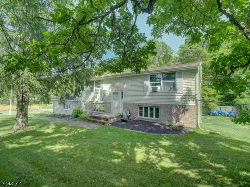Spacious bi-level home on nearly 3/4 acres in Crandon Lakes section in Newton.  300' frontage. Bright and airy kitchen with newer refrigerator and separate dining area.  Large Living Room with sliders leading to patio and large, newly fenced-in yard.  Other features: newer flooring on second level, newer wood burning stove, recessed lighting in kitchen, a heated, oversized two-car garage.  Home has two bedrooms, plus full office and another room used as a guest room. New, 2-bedroom town verified septic installed in 2020. Freshly power washed. Lease to own solar panels are $104/month via Skyline Solar.  Minutes from Crandon Lake--2 sandy beaches available for swimming, fishing, boating, playgrounds, fields for sporting events.  Conveniently located near Route 206 for commuting, shopping, golf and ski resorts.