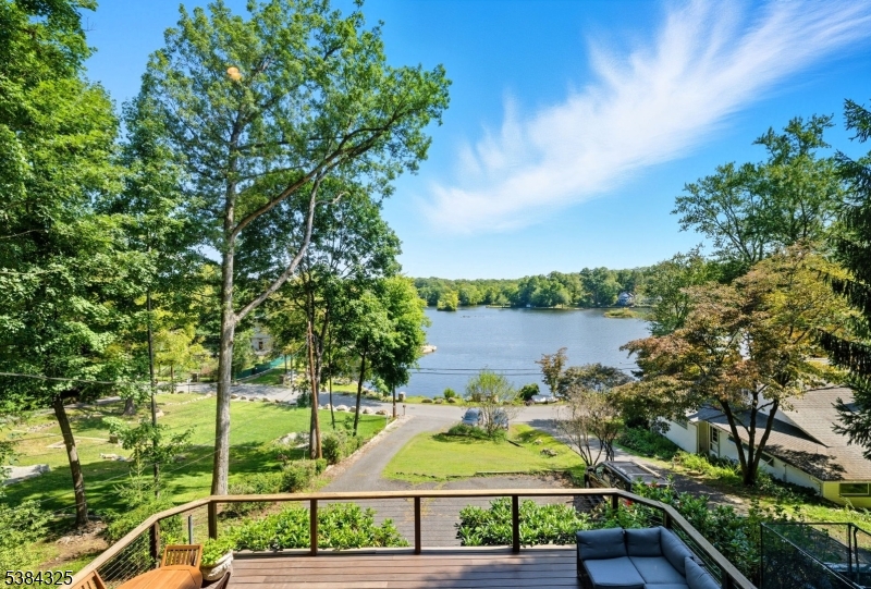 Picturesque Lakefront Location on half an acre on beautiful Cedar Lake! Sitting on top of a wooded property with LAKE VIEWS AND direct, private LAKEFRONT access. Functional floorplan, design, features & numerous windows to create bright living space which enhance the Lake views. The first floor layout includes a large living room with a wood burning fireplace. Smartly designed to give the illusion that extends out onto the oversized front deck from Anderson french doors. Recently renovated kitchen with gorgeous granite countertops and access to the wooded backyard & deck. Formal dining room. Convenient powder room. 1st floor bedroom and full bath. Hardwood floors throughout. Upstairs, 2 generous sized bedrooms both with en-suite full baths. The primary suite boasts cathedral ceilings with large picture windows, a soaking tub & a custom wardrobe with laundry which leads to the updated bath & stall shower. Second generous sized bedroom with wood burning fireplace & full bath with tub shower. Perfect layout for entertaining or just everyday living. Make this home yours! Desirable neighborhood and Cedar Lake community. Private lakefront access & private dock. Beaches, fishing, boating, etc. Just a stones throw from Main Beach & Boat Docks. Easy access to DWTN Denville, major highways & NYC Direct Mass Transit. TONS of Shopping & Restaurants Nearby. Public utilities (Gas on street). -- Also includes lakefront property Block 60906 & Lot 35. New roof in 2012.