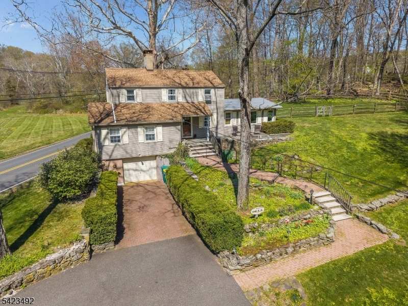 Charming Colonial owned for decades by world-renown artist Bill Bell offering 3 Bedrooms and 2 Full Baths with timeless character. Wood floors, a fireplace, and the beamed ceiling bring warmth and architectural character to the home's main living space. The bright, sunlit family room, formerly the owners' art studio, provides a versatile space for creative and everyday living.The first-floor primary bedroom is paired with an adjacent full bathroom for added convenience. The kitchen features granite and wood countertops, soft closing cabinets and easy access to the laundry room located off the kitchen. A new stockade privacy fence enhances outdoor enjoyment, while mature landscaping and a wooded lot create a peaceful natural backdrop bordering preserved farmland. The location offers excellent convenience with easy access to Rt 22, Rt 31, and I-78, plus nearby shopping, dining, schools, recreation, and entertainment in Clinton, Flemington, and Lebanon Borough.
