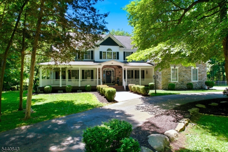 Located in the sought-after High Crest Lake section of West Milford, this exceptional custom estate offers approximately 7,200 structural sq ft on 5.35 private fenced acres. Designed for both everyday living and grand entertaining, the home features a dramatic two-story great room, private home office, home gym, and a designer kitchen with ceiling-height custom cabinetry, waterfall quartz island, premium appliances, and herringbone hardwood flooring. The luxurious primary suite offers vaulted ceilings, dual walk-in closets, a spa-inspired bath, and an attached sitting room. A ground-floor guest suite with full bath provides exceptional flexibility, while the fully renovated walkout lower level features a second kitchen, family room, bedroom, and new full bath with heated floors. Recent improvements include two new HVAC systems, two 100-gallon water heaters, renovated bathrooms, updated finishes, and extensive custom upgrades throughout. Outdoor amenities include a full-length deck, covered patio, wraparound mahogany porch, finished 3-car garage, horseshoe driveway, 21-zone irrigation system, generator hookup, multiple entertaining areas, and a stunning 12,000-gallon koi pond with double waterfalls. Optional High Crest Lake membership offers access to lake amenities and community activities. Just over 20 miles from New York City, this rare estate offers luxury, privacy, and space without compromise.