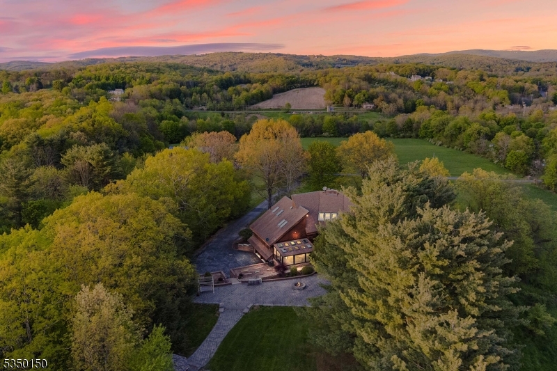 Enjoy Mountain Views 90 Acres and tons of privacy in this custom, contemporary Estate full of possibilities.  Whether you are looking for a private escape or a unique development opportunity this fully upgraded home sits on acres of space waiting for expansion and exploration.  At the center of the property, you will find a primary home with luxury amenities such as a commercial grade kitchen designed by Poggenpohl, a stunning 18-ft hearth stone fireplace, 20-ft ceilings, exposed wood beans, and white oak wooden floors.  Natural light streams through the many windows, including the skylights and floor-to-ceiling windows in the main living area, and AMAZING VIEWS! There's over 3500 sq ft of outdoor entertaining space, with a spacious stone patio, firepit, and a fully equipped built in outdoor kitchen.                Barn with 9 custom built stalls, rubber mats, and 18 Ft rolling doors.  No matter what your passion is, hunting, fishing, equestrian, or development, this lovely New Jersey property can be adapted to fit your plans!  So many options available!