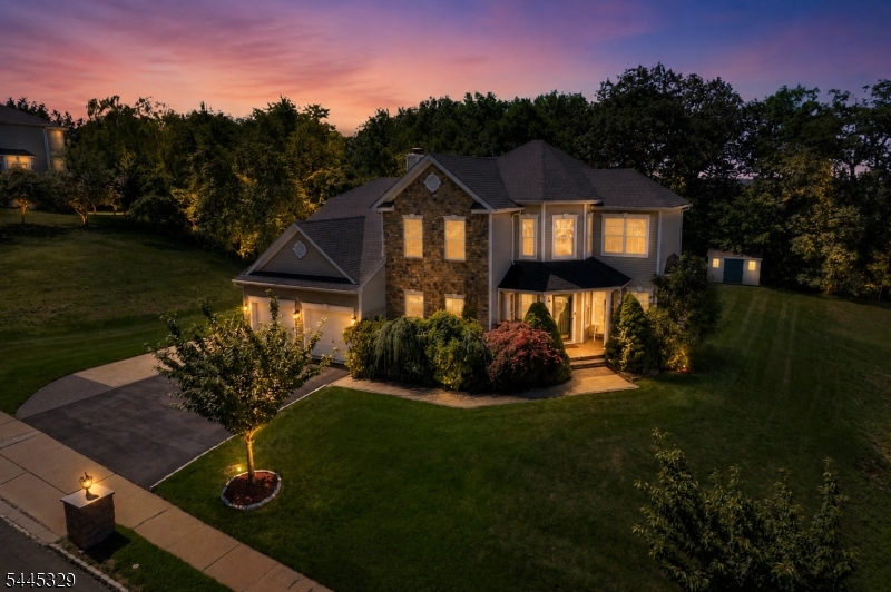 Luxury, privacy, and exceptional indoor-outdoor living define this beautifully updated residence in The Peaks, one of Morris County's premier luxury communities. Situated on a premium oversized lot backing to protected township land that cannot be developed, this exceptional home offers remarkable privacy. At the heart of the home is a designer chef's kitchen featuring a Wolf 6-burner range with vented hood and pot filler, Monogram double convection wall ovens with warming drawers, a paneled Monogram French door refrigerator, an under-counter double pull-out refrigerator, and a farmhouse sink with pull-down faucet, filtered water faucet, and soap dispenser. The open layout flows effortlessly into spacious living and dining areas, creating an ideal setting for everyday living and entertaining. Outside, enjoy professional landscaping, a custom paver patio, pergola, fire pit, and outdoor kitchen with built-in grill, wet sink, and refrigerator. The exceptionally flat backyard is a rare offering within The Peaks. The finished lower level offers expansive recreation space, abundant storage, and a second summer kitchen complete with a refrigerator, wine refrigerator, dishwasher, sink, and additional prep space. Residents enjoy tennis and basketball courts, playgrounds, scenic walking streets, beautifully maintained common areas, low HOA fees, and convenient access to shopping, major highways, NJ Transit, and New York City.