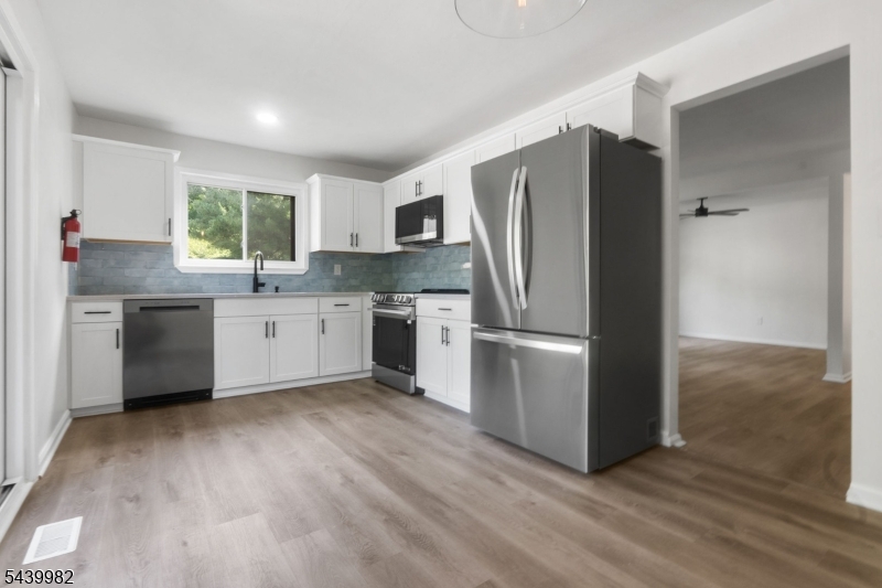 Welcome home to this stunning, fully renovated multi-level condo that checks every box! From the moment you step inside, you'll be captivated by the bright, open layout and high-end finishes. The beautifully updated kitchen is the heart of the home, boasting gleaming quartz countertops, stainless steel appliances, and an elegant marble backsplash perfect for cooking and entertaining. Step directly outside to your private deck, ideal for morning coffee or evening relaxation. Luxury vinyl plank flooring flows seamlessly throughout, complementing the fresh, modern aesthetic at every turn. The spacious primary bedroom features a generous walk-in closet, while the fully renovated full bath offers a fresh, clean aesthetic. A convenient half bath on the lower level adds everyday functionality. The versatile lower level is a true bonus - use it as a den, family room, home office, or easily convert it into a second bedroom, offering flexibility to suit your lifestyle and needs. A brand-new exterior oil tank provides peace of mind for years to come. Set within a well-maintained complex that backs to a beautiful, wooded lot, residents enjoy resort-style community amenities including a sparkling pool and a community room perfect for gatherings, events, or simply connecting with neighbors. Commuters will love the quick and easy access to major highways, putting you minutes from everything New Jersey has to offer.