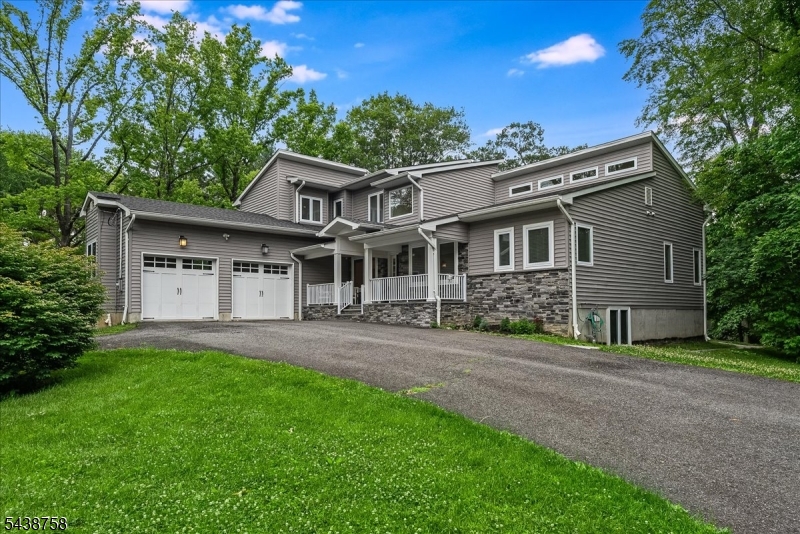 Rare offering in the heart of Morristown, this custom-built residence crafted by its Owner-builder just 10 years ago blends timeless design with modern sophistication, quality construction, and a level of detail increasingly difficult to find. A welcoming front porch and circular driveway set a refined first impression. Inside, a dramatic two-story great room is filled with natural light and serves as the architectural centerpiece. Open-concept flows seamlessly into kitchen and living room, an effortless setting for both intimate living and elevated entertaining. A walk-in pantry, mudroom, and laundry are discreetly positioned to enhance daily function. Main level offers a private office, the ideal space for remote work, a library, study, or quiet retreat, thoughtfully positioned to offer separation from the home's primary gathering spaces. First-floor primary suite provides the ease of true single-level living, a generous walk-in closet and a spa-inspired bath with soaking tub and oversized shower, designed as a private retreat. Upstairs, three bedrooms, including a unique hidden storage space that adds both charm and practicality. Walk-out lower level significantly extends the home's footprint, offering high ceilings, full-size windows, a bedroom, bonus room, full bath, a sink area, & second laundry setup. ideal for guest accommodations, in-law suite, or a refined recreation. Opens directly to a patio and generous backyard, to create your own outdoor oasis.