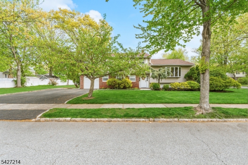 Welcome to this sun-drenched, beautifully maintained sugar maple split-level home, perfectly situated on one of the most picturesque streets in town.  Brimming with warmth and charm, this residence offers the perfect blend of style and functionality across four thoughtfully designed levels. Highlights include a new roof(2022), C/A/C(2024), an updated kitchen with newer appliances, renovated bathrooms, newer deck and windows, freshly painted interiors, gleaming hardwood floors, and recessed lighting throughout.  The four levels of living space provide a flexible layout for modern living.  The unfinished basement offers ample storage and workshop space, ready for a full transformation.  The ground level features a large guest bedroom also suitable as a home office or great room, versatile family room, and a powder room.  The first floor boasts an inviting living room and dining area with high ceilings, along with a MEIK.  Step outside to a spacious patio and deck overlooking a large, level backyard with fabulous curb appeal--a true sanctuary ideal for weekend gatherings or quiet moments of relaxation, surrounded by lush landscaping.  Enjoy an exceptionally convenient location with easy access, close to transportation and vibrant downtown shops.  All room and floor plan dimensions are approximate.