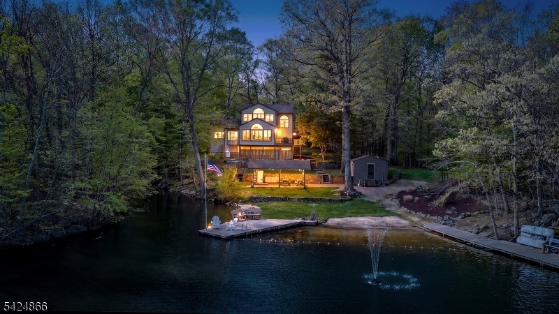 Prepare to experience one of the most extraordinary lakefront settings in the tri-state area, where sweeping water views, unmatched privacy, and a true sense of escape define everyday living. Set within the exclusive Lake Iosco community, a 400-acre private lake shared by just 43 residents, this property delivers a rare combination of serenity and accessibility while remaining within close proximity to NYC. Live and entertain with ease as this exceptional lakefront property offers: its own private sand beach, multiple docks, two boat houses including one fully enclosed, and outdoor space designed to embrace the waterfront setting. Enjoy boating, fishing, swimming, and endless lake activities directly from your property, while a hiking trail begins on site and connects to Norvin Green State Forest. The home features an open, light-filled layout with walls of glass capturing the lake, a main level bedroom, and a second floor devoted to a primary suite with breathtaking views. The walkout lower level adds versatility with two guest areas and a full bath. A detached two-car garage with workshop, along with an additional built-in garage, completes the offering. Home is a 2 bedroom for tax purposes, but a functional 3 or 4 bedroom. This is a rare opportunity to own a truly special lakefront property. Schedule your private tour today.