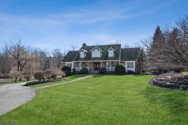 Picturesque private retreat surrounded by natural beauty!Spacious & spotless Center Hall Colonial is nestled on 1.5 flat, park-like acres on a quiet cul-de-sac in Kinnelon. This stately residence features beautifully scaled rooms, generous light, exquisite architectural details & sweeping views over expansive lawns & woods. A stone paver walkway & a covered front porch guide you inside to a 2-story foyer with a graceful quarter-turn staircase. Warm hardwood floors gleam across the first floor living room with a vaulted ceilings, fireplace & the formal dining room with an elegant chair rail, parquet floors & crown molding. The light-filled eat-in kitchen features granite counters, rich wood cabinetry & a breakfast nook with sliding glass doors to the deck, the perfect setting for entertaining & sunset cocktails overlooking the private property. The layout continues with a large library/office, a family room, a powder room & laundry room. The first-floor primary bedroom suite includes two WIC & a lavish en-suite bathroom with a jetted tub & oversized glass shower. Upstairs are 3 additional bedrooms, a bonus room that could be used as a den/guest room & a full hall bathroom, while the fully finished walkout basement has a spacious recreation room, full bathroom, ample storage & access to the attached garage. Along with the option to join some of the close by lakes & just minutes to Pyramid Mountain Park, this home is near top-rated schools, RT 23 & I-287, stores & restaurants.
