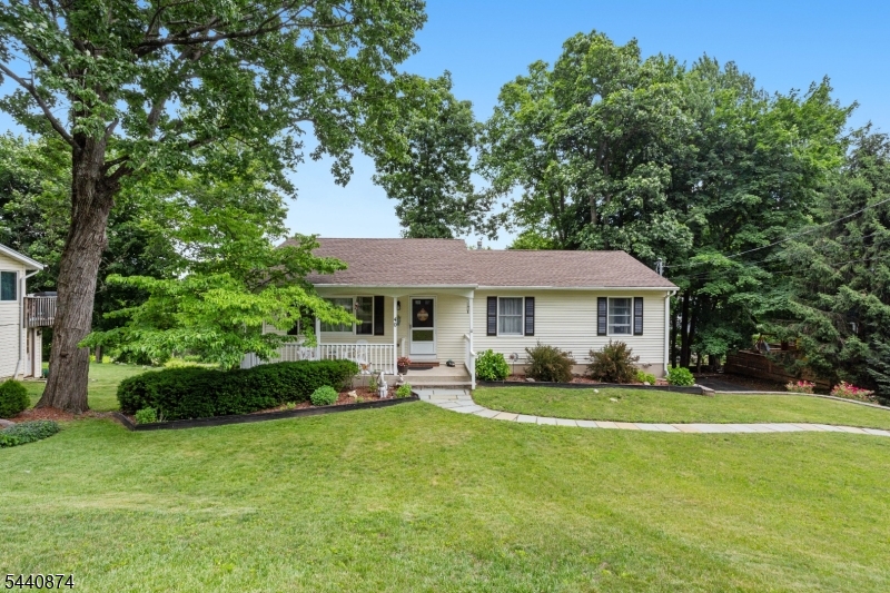 Welcome to 40 Shadowy Lane   where charm, character, and West Milford living come together. Tucked just minutes from Pinecliff Lake, this beautifully maintained 3-bedroom, 1.5-bath raised ranch is the one you've been waiting for. Curb appeal sets the tone immediately   mature trees, lush landscaping, and a welcoming front porch invite you in. Inside, soaring vaulted ceilings, gleaming hardwood floors, and abundant natural light greet you in the open living room. The layout flows seamlessly into a spacious dining area and a fully updated kitchen featuring white cabinetry, marble-look countertops, a sea glass tile backsplash, recessed lighting, and a butcher block island. Step outside to a backyard made for living   a raised deck with retractable awning overlooks a private, tree-lined yard with a gravel fire pit area, patio, and string lights perfect for warm evenings. Three comfortable bedrooms offer hardwood floors and ceiling fans, while the renovated full bath features a walk-in shower with floor-to-ceiling tile and frameless glass door. A half bath and lower-level laundry complete the picture. The big stuff? Already done   new roof and mechanicals. Just move in and enjoy everything West Milford has to offer: hiking, kayaking, farmers markets, and a small-town feel that's genuinely hard to find.