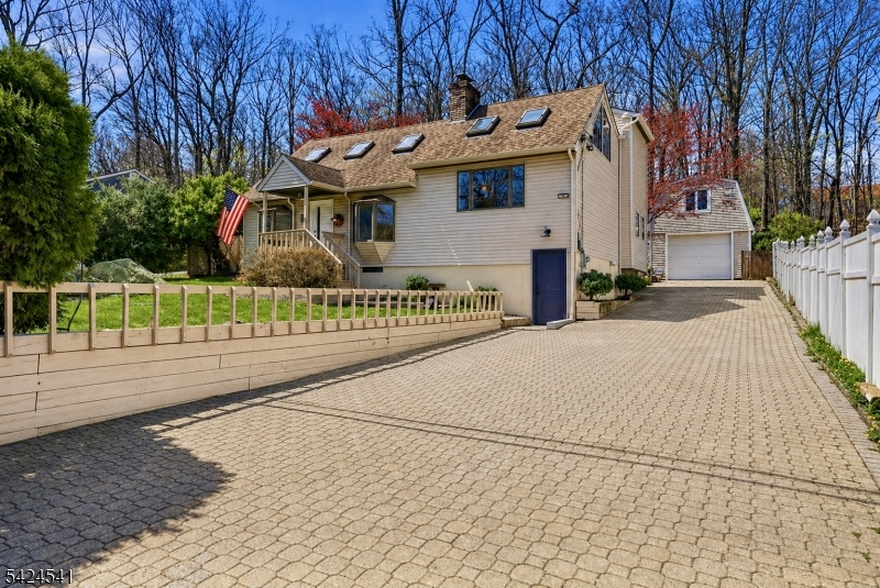 Completely one of a kind home nestled in the sought-after Lake Shawnee section, this breathtaking 3-bed, 2-bath completely renovated contemporary is a rare fusion of bold architecture, designer finishes, and a lifestyle most only dream about. Step inside and the story unfolds, soaring vaulted ceilings, a wood-burning fireplace, and an abundance of windows and skylights that flood every room with extraordinary natural light. The sun-drenched glass solarium and oak staircase with black iron railings set a tone that is sophisticated and unforgettable. The versatile in-home loft is ideal as a fourth bedroom, home office, or creative retreat. The chef's kitchen stuns with granite countertops, stone backsplash, white shaker cabinetry, and induction cooktop all bathed in sunlight from the surrounding walls of glass. Both fully renovated bathrooms are showstoppers, featuring soaking tubs, walk-in porcelain and slate tile showers, floor-to-ceiling glass walls, slatted wood vanities, with modern sconces. The bonus that changes everything: a detached oversized garage with a fully finished heated loft, media room, studio, or guest suite. The epoxy-floored garage level is ready to house your prized vehicles or entertain in style. Minutes to top restaurants, major commuting routes, and ideally positioned to enjoy everything Lake Shawnee and Lake Hopatcong have to offer. Outside, a covered deck, gazebo, greenhouse, and built-in grill station overlook a lush, private backyard retreat.