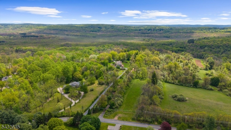 Rare opportunity to build your ultimate custom dream home on 12.5 private, rolling acres in prestigious Chester Township! Nestled in the desirable R2 zone, this unique flag lot offers the ultimate in privacy and seclusion. The property is beautifully wooded and currently farm-assessed under a woodland management plan, offering significant tax benefits.  The land opens up to a spectacular hilltop crest where the current home sits, boasting breathtaking, panoramic views that truly go on forever. Imagine waking up to endless horizons and designing a custom estate that perfectly frames these unmatched vistas. The acreage directly adjoins the pristine Black River Wildlife Management Area, providing a permanent natural buffer, tranquil surroundings, and effortless access to outdoor recreation right in your backyard. Please note: The existing home on the property is currently occupied but is considered a tear-down and is being sold strictly in "as-is" condition. Value is entirely in this incredible land. All visitors must have a confirmed appointment prior to entering the property?absolutely no trespassing. Buyers are responsible for conducting their own due diligence regarding building requirements, variances, and utilities. Bring your architect, bring your vision, and claim one of Chester?s finest view lots today!