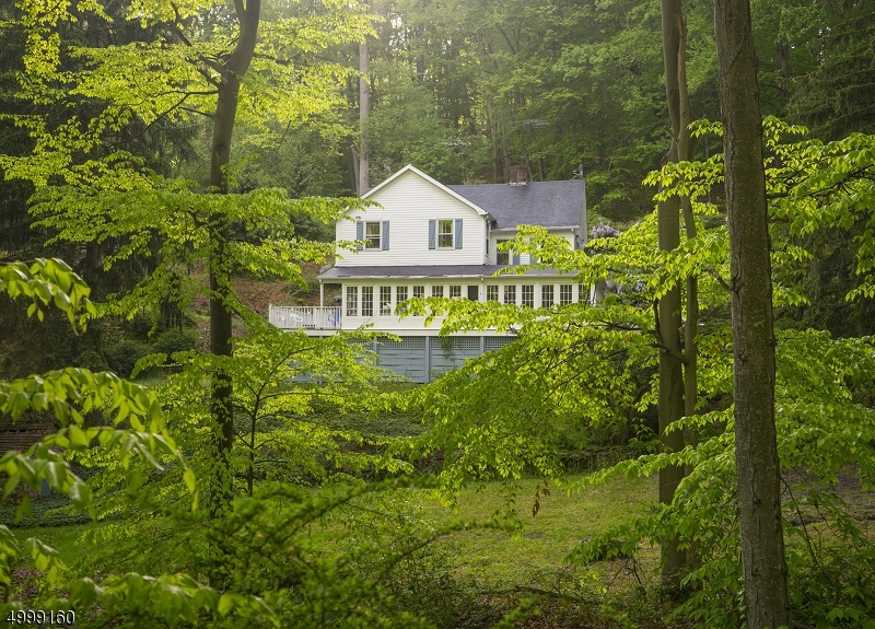 Charming home on gorgeous 5+acres of mostly wooded property with stream.  House in need of work (being sold as-is) + outbuildings.