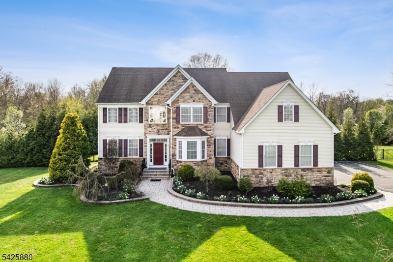Built in 2012 and just moments from town, this exceptional Northeast facing estate is set on 2 fenced acres at the end of a cul-de-sac, among other fine homes. A grand 2-story foyer with wrought iron balusters & oak treads welcomes you into an open layout with hardwood floors & elegant formal living & dining rooms. The soaring family room features a vaulted ceiling, rear staircase & wood-burning fireplace. The adjacent eat-in kitchen is a standout with a center island, double wall oven, gas cooktop with hood & breakfast area overlooking a resort-style backyard. A private study with french doors, mudroom & updated powder room complete the main level. Upstairs, enjoy 4 spacious bedrooms & 3 full baths, including a princess suite, Jack & Jill bath & a luxurious primary suite with double-door entry, sitting room, sauna, 2 oversized walk-in closets, tray ceiling & spa-like bath with jetted tub & dual vanity. Tile flooring throughout the bedrooms offers a clean, modern aesthetic. Step outside to your private retreat featuring a heated in-ground pool (2025 heater & pump), spa, expansive paver patio with pergola & firepit, vegetable garden & gorgeous sunset views. Additional highlights include public sewer, OWNED solar panels, whole-house generator, 2-zone heat/AC, full basement, 3 car garage, lawn irrigation, shed & driveway pickleball court. All appliances remain. Ideally located near Neshanic Valley Golf Course, kayaking, hiking, Bridgewater, Princeton, NYC train & major highways.