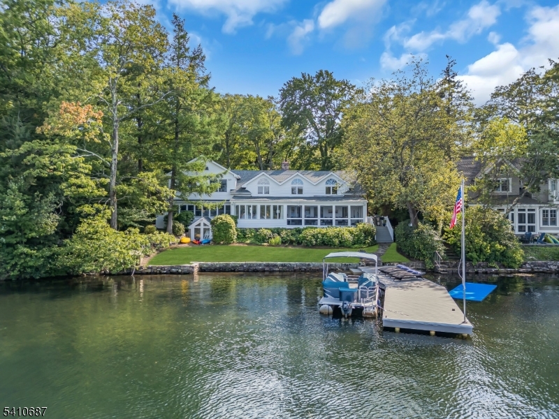 Experience the pinnacle of luxury lakefront living at this exquisite 4-5 bedroom, 4.5 bath residence perfectly situated on the private lake of Green Pond, New Jersey's cleanest, spring-fed glacial lake. Located within the coveted 66-homeowner enclave of Lake End Corporation, this exceptional property offers breathtaking water views, timeless craftsmanship, and modern upgrades throughout. The heart of the home is the Great Room, anchored by a striking native stone fireplace with wood burning insert, while the adjoining family room with a gas fireplace creates a second inviting gathering space. The updated chef's kitchen features quartz countertops, new high-end stainless steel appliances, a spacious island with gas cooktop, and butler's pantry ideal for entertaining. Upstairs, the primary suite includes a renovated ensuite bath and expansive walk-in closet. Three additional bedrooms and two new full baths provide comfort and flexibility for guests. Recent improvements include: new 4 bedroom Rich Kimble septic, full interior repainting, refinished and new hardwood floors, all-new lighting, four new & renovated bathrooms, a new tankless hot water heater, new HVAC system, infrared sauna, new kitchen appliances and new patio and landscaping. Enjoy the stunning views from the screened porch, newly landscaped yard, or your private year-round dock... the ultimate setting for relaxation or recreation.