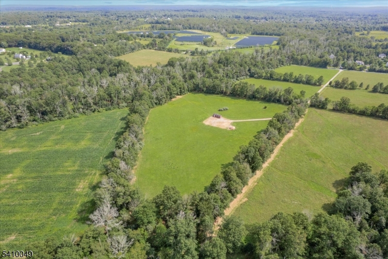 Attention equestrians, nature lovers and discerning land buyers! A rare opportunity to build an equestrian utopia or exceptional estate property in a serene setting in Kingwood Twp. Set along a quiet country road, this exceptional 17.63-acre parcel includes ownership of a portion of the Lockatong Creek, w/ trails cut on both sides, offering a peaceful and picturesque setting with endless possibilities. Bordering 26 acres of preserved land, the property enjoys protected views and long-term privacy. A well is already installed and a 4-bedroom septic has been approved and is on file w/ the County Board of Health, providing a strong foundation for future development. The designated homesite sits approx. 1,200 feet from the road, tucked behind 2 distinct mature tree lines, creating a secluded setting. 10-ft-wide gravel driveway leads to an expansive 85' x 80' gravel turnaround pad, ideal for ease of access, equipment or horse trailers. Open fields with hay and ready for grazing, while the stream and wooded trails invite exploration and recreation. Whether your vision includes an equestrian estate, a private country retreat, or a legacy property to hold and enjoy for generations, this land offers the rare combination of natural beauty, privacy, and existing infrastructure. Conveniently located near shopping & charming river towns of Frenchtown, Stockton, Lambertville and New Hope w/ easy access to Routes 202 & 78.  Approx. 60 mins to PHL & 90 mins to NYC.