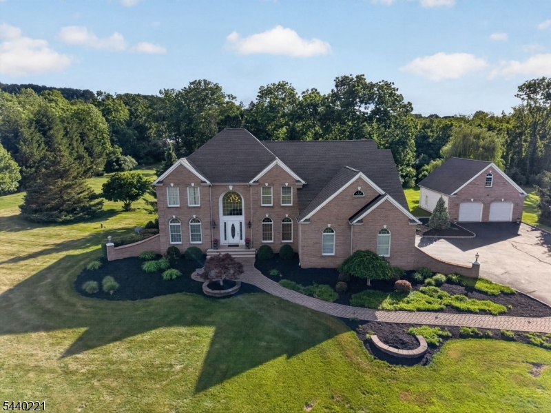 First time offered by the original owner! This custom brick-front 4-bedroom, 2.5-bath Colonial features a dramatic two-story foyer, center-island eat-in kitchen open to the two-story Great Room with wood-burning fireplace, formal living and dining rooms, and a first-floor home office. The spacious primary suite includes a sitting room, oversized walk-in closet, and en-suite bath with frameless glass shower and soaking tub. Attached 2-car garage plus a detached oversized 2-car garage?perfect for car enthusiasts, hobbies, or extra storage. Enjoy a private setting with an expansive two-tier tumbled stone patio ideal for relaxing or entertaining.