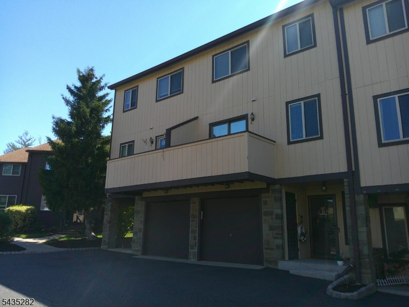 Spacious 3-story townhome with abundant storage and a convenient commuter location! Ground-level entry foyer leads to a large storage/utility room. The main level features a bright living room, family room, dining area, kitchen, powder room, and a charming brick wood-burning fireplace. Sliding doors open to a private front balcony and rear deck, perfect for relaxing or entertaining. Upstairs offers a spacious primary bedroom with updated en-suite bath, a second generously sized bedroom, oversized floor-to-ceiling closets, and additional hallway storage.Conveniently located near Routes 22, 28, and 287 with easy access to shopping, dining, and everyday conveniences. Great opportunity for comfortable townhome living with space, storage, and accessibility!