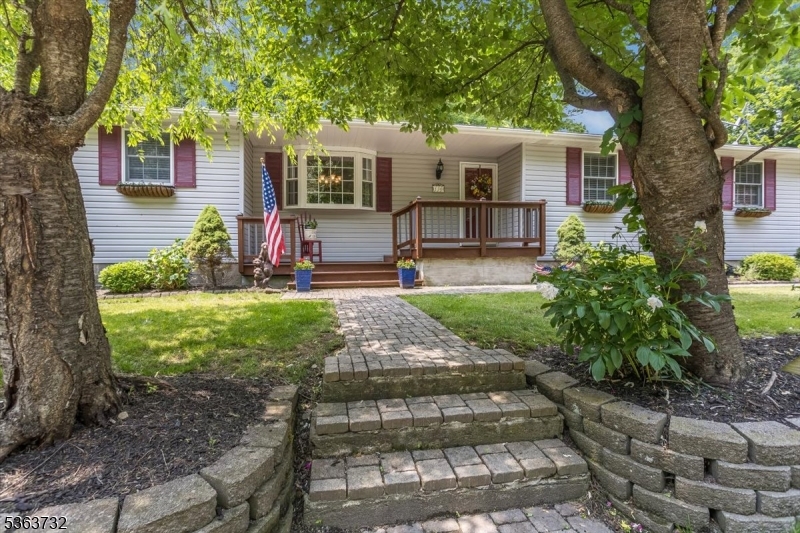 Move right in to this beautifully renovated one floor living custom ranch home!  The owners customized this home in 1997 adding vaulted ceilings in the Living/Dining rooms and Kitchen. One floor living at its best.  This 3 bedroom 2 full bath home with a bonus Den and 3 Season Room has so many updates including the following:  Roof 2022, Furnace 2023, Water Heater 2024,  main & Primary bath redone in 2020.  The home is designed with an open concept/easy flow between the Kitchen, Living rm, Dining rm, 3 Season Rm and den.  Great for entertaining guests or just relaxing under the high ceilings.  The 3 Season Rm is a plant lovers paradise & nice retreat, with new vinyl flooring 2023 & walls of glass and sliders to the back yard.  The Laundry Room is off the kitchen with a pantry & access to the 1 car garage.  A full basement for storage  and a craft/project room too. Do not worry if there is a power outage.  There is a generator hookup and the owner is leaving their portable generator behind.  Step outside to this nature lovers dream.  There is a front porch 2 back decks & a patio.   The gardens are beautiful and the home is surrounded with beautiful plantings, a wooded back area, & large natural rocks that hug the back deck area.  Thee are two storage sheds.  There is parking for 10+ so invite everyone! backs to hundreds of Green Acres & more across the street