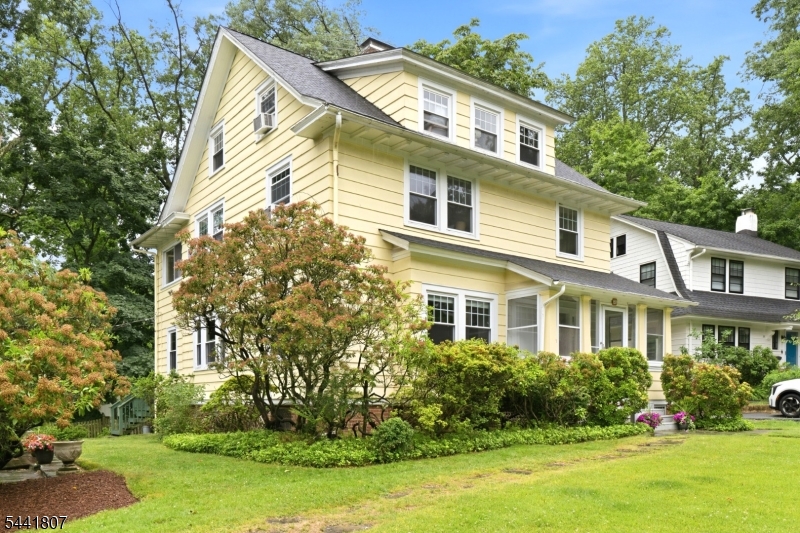 Offered for the first time in 57 years, this classic South Orange Colonial is ideally situated on sought-after Glenside Road, a quiet dead-end street just off Ridgewood Road. Set on one of the larger lots in the neighborhood, the property features expansive front lawns, bluestone walkways, and a picturesque wooded backdrop.Enjoy every season from the enclosed front porch, spacious rear deck overlooking the glen, and inviting side patio. Inside, timeless architectural details blend with thoughtful updates throughout. The first floor offers a gracious entry hall, oversized living room with beamed ceiling and wood-burning fireplace, formal dining room, den/library with built-in bookcases, light-filled kitchen, and convenient powder room.The second floor features three bedrooms and two full baths, including a primary suite with en-suite bath and adjoining sunroom overlooking the wooded setting. A full third floor expands the home's versatility with an additional bedroom, bonus room, full bath, and ample storage.A detached two-car garage, generous driveway, and mature landscaping complete the property. Ideally located near vibrant downtown South Orange, parks, the Baird Community Center, pool, tennis and pickleball courts, and about .5 mile to Midtown Direct train service to NYC. Lovingly maintained and updated over the years, this special home offers charm, space, character, and the opportunity to make it your own in one of South Orange's most desirable neighborhoods.