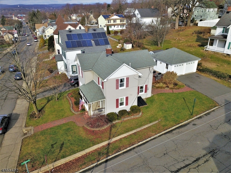 Picturesque corner lot colonial located just a few blocks from direct trains to NYC! Walk in through your beautiful front porch and landscaped yard. Hardwood floored living room surrounded by big windows and natural light which opens to spacious formal dining room. Updated eat-in kitchen with granite counter-tops, stainless steel dishwasher, and stove. Kitchen door leads to large custom paver patio and massive two car garage! Second floor offers two generously sized bedrooms with brand-new wall-to-wall carpeting throughout. Updated spa-like bathroom and third bonus room which could be used as an office, closet, or make-up room! Basement with Bilco door, laundry, and plenty of storage space!