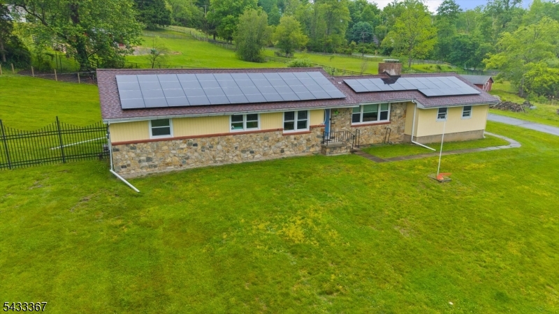 Nestled along a quiet country road in desirable Lebanon Township, this charming energy-efficient ranch offers peaceful country living on a beautiful park-like setting. Set on nearly 4 private acres, the property features a picturesque 1-acre pond, newer fencing, and plenty of open space to relax, entertain, and enjoy the outdoors.Inside, the open-concept floor plan is highlighted by a beautifully updated kitchen featuring cherry cabinetry, quartz countertops, stainless steel appliances, an induction cooktop, and double wall ovens. Hardwood floors flow throughout the home, while oversized windows fill the living spaces with natural light. A stunning wood-burning stone fireplace creates a warm and inviting focal point for cozy evenings.Recent upgrades include a newer roof, solar panels for energy efficiency, multi-zone heating, central air conditioning, a remodeled full bath, and updated lighting throughout. The fully finished basement offers exceptional bonus living space and abundant storage, including cedar closets.Outside, a spacious deck overlooks the scenic property and provides the perfect setting for summer entertaining. With first-floor laundry and convenient one-level living, this home is ideal for downsizing, purchasing your first home, or simply enjoying the tranquility of country living.