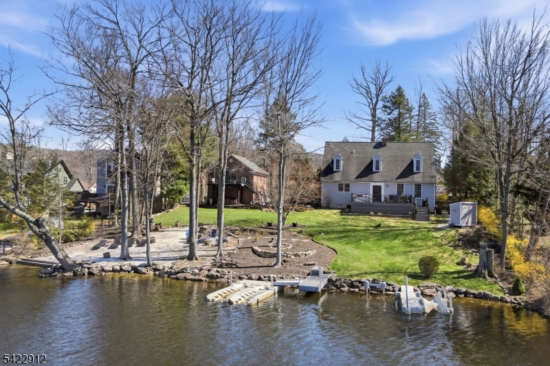 An Elevated Lakefront Experience with Presence & Personality! This Stunning Home is Set Along 140ft of Waterfront! Renovated in 2019-2020, the Custom Kitchen Blends Design & Performance with an Elongated Island Offering Full Length Breakfast Seating & Spacious Dining Area! Wolf Double Wall Ovens & Gas Cooktop, Viking Microwave Drawer, and a Newly Installed Dishwasher! The Main Living Space is Both Dramatic and Welcoming, Featuring High Ceilings, a Brick Fireplace with Wood-Burning Stove Insert, and a Custom Paneled Accent Wall! With Multiple Exits Points to the Deck from Back Foyer and the Patio from the Kitchen French Doors Create Effortless Indoor Outdoor Access! The Primary Bedroom Offers a Peaceful Retreat with its Own Wood-Burning Fireplace, Complemented by a Beautifully Finished Shared Hall Bath with a 2nd Bedroom on the Upper Level! The Lower Level Showcases a Spacious Recreation Room with Reclaimed Barnwood Sourced Locally from Florida, NY, Custom Cabinetry, Dedicated Storage, an Office, & Laundry Room with Folding Countertop and Under Storage!  Above the 2 Car Garage is a Private Studio with Full Bath Providing Ideal Flexibility for Many Creative Uses!  Enjoy the Flowering Landscaped Grounds, a Firepit Area! Capture Unforgettable Sunsets & Enjoy Front Row Views of the Annual 4th of July Fireworks from Your Own Space! A Property that Sets Itself Apart in Both Setting and Design! Come Experience it Today! 2 Bedroom Verified Septic!