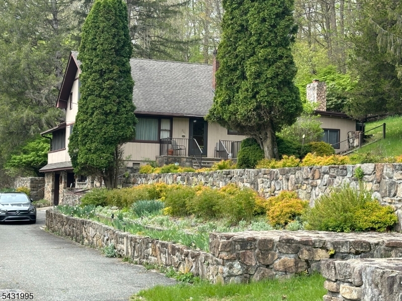 Situated on over 4 acres of private, serene land, this property offers a rare opportunity for a sustainable lifestyle. The grounds are a gardener?s paradise, featuring meticulously maintained flower and herb gardens, artisan stone walls, and a large, fenced vegetable garden perfect for farm-to-table living. The expansive acreage provides ample space to expand your hobby farm, with plenty of room to cultivate fruit trees or establish a coop for chickens. Ideally located, this home is within walking distance of the NJ Transit train station and Centenary University, home to the Sitnik Theatre. Residents will enjoy the vibrant heart of Hackettstown, offering boutique shopping, local microbreweries, a distillery, and a diverse range of fine and casual dining.This custom-built residence includes four generously sized bedrooms, a formal living room, and a family room highlighted by an artisan stone fireplace. The home also features a formal dining room, a well-appointed kitchen, and a finished basement. A standout feature is the unique 19x20 three-season room, complete with vaulted ceilings, skylights, and ceiling fans, providing a perfect vantage point to oversee your private estate. This exceptional property is a must-see; schedule your private showing today.