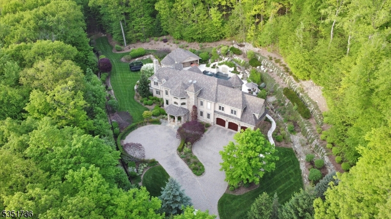 Nestled against the breathtaking backdrop of Ramapo Mountain State Forest, this exceptional 10.92-acre estate redefines luxury living. The home's resort-like backyard is an entertainer's dream featuring a stunning pool, spa, outdoor kitchen, full service cabana and lounge areas designed for memorable gatherings or serene relaxation. Custom-crafted with meticulous attention to detail, the residence seamlessly blends elegance and comfort, offering panoramic views from every window, expansive living spaces, an elevator to all levels, and top-tier finishes throughout. Whether you seek a private sanctuary or a showplace for entertaining, this one-of-a-kind home offers it all alongside direct access to miles of pristine forest trails. Surrounded by nature, yet close to shops, dining, and top-rated schools, this is the best of both worlds.