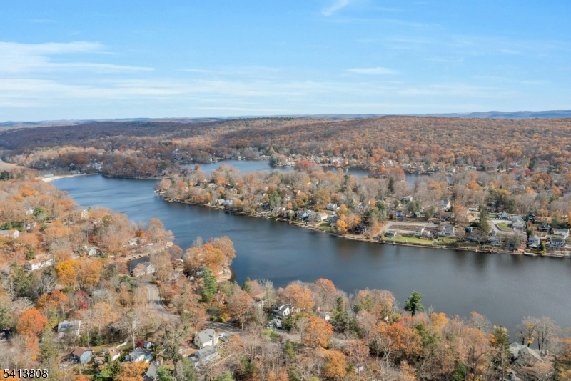 THIS IS IT! A CHARMING 4-BEDROOM COLONIAL w/RENOVATED KITCHEN  nestled in the desirable Upper Greenwood Lake community.  Featuring Impressive whole house generator, new 4-bedroom septic system/2025, newer boiler, lg driveway, 1 car garage + storage, & basement. This homelife blends classic cottage style with modern updates, offering the perfect setting for a comfortable living. A beautifully renovated kitchen is the heart of this home, featuring a spacious island, updated finishes, and a breakfast area. The living room offers a warm and welcoming atmosphere with a sophisticated fireplace and spacious dining area. A convenient first-floor bedroom & full bath provides flexibility for guests, a home office, or living. Upstairs, you'll find additional 3 bedrooms & renovated full bath, plus access to an upper deck outdoors! The Primary Bedroom has views from a lg bay window and walk-in closet. Step outside to enjoy two separate decks & tiered lawns, offering plenty of space for outdoor gatherings, gardening, or simply unwinding. LOCATION:2 mi to Wawayanda State Park for hiking & lake activities! Just 5 miles to WARWICK's shopping, farms & markets, restaurants & LIVE MUSIC VENUES  & just 5 miles to WMilford's grocery, Banking, TJMaxx, Hardware & more... Don't miss this wonderful opportunity to own a move-in ready home in a sought-after lake community, JUST IN TIME FOR SUMMER & AUTUMN LIFE AT THE LAKE! POTENTIAL AIRBNB w/Local Seasonal Activities!  SELLER IS MOTIVATED.