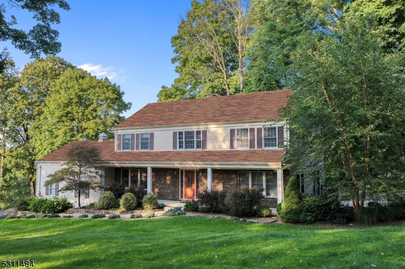 Impeccably maintained and beautifully updated! This completely move-in ready colonial has views of Budd Lake. Some of the many features include Control 4 Audio Smart Home system with amp, wifi, cameras, alarm system, etc., covered, rocking chair front porch, entertainment sized patio, welcoming foyer with hardwood flooring, open floor plan, large formal dining room, livingroom/family room combo with woodburning fireplace, built-ins,recessed lighting and French door to newer patio, gourmet kitchen with Wolf gas cooktop stove with pot filler and range hood, center island with veggie sink, breakfast bar, Fisher-Paykel 2-drawer dishwasher, double electric wall ovens, pantry and powder room complete the first level. Upstairs has primary suite with huge bedroom, hardwood flooring, 2 walk-in closets, access to storage over garage, and full bath with stall shower, jetted tub, bidet and new double marble vanity.  Three additional spacious bedrooms, all with walk-in closets, and full updated guest bath with new double vanity and tub shower, pull down attic stairs to more storage complete the second level. Finished basement includes exercise room with recessed lighting, high ceilings and rec room with storage closets, as well as unfinished storage room with shelving.  Some additional features include raised bed veggie garden, storage shed, central air, speakers throughout the home, excellent Mt. Olive schools and located minutes to Rts. 46 and 80. Tearoff and new roof in September 2024.