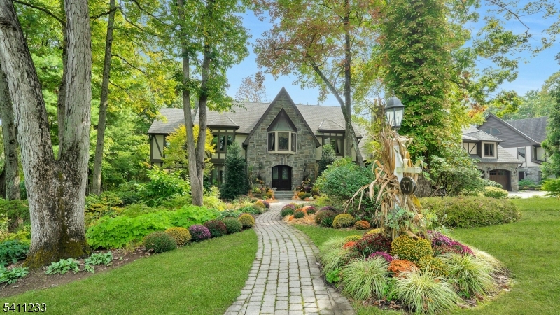 Breathtaking in every way, this extraordinary Manor Colonial is set on 2 private, tree-lined acres. With 8,000+ SF of refined living space, this home delivers architectural distinction & seamless indoor/outdoor luxury. A dramatic foyer introduces expansive formal living & dining Rms, a private Library/Home Office & a sophisticated Family Rm w/ vaulted loft & casual dining. A sun-drenched Sunroom captures tranquil views of the manicured grounds. Hand-painted murals & custom wood cabinetry elevate the interiors. The 2008 expansion transformed the home into an entertainer's dream, adding a spectacular Great Room with custom bar & a window wall opening to an elegant stone patio w/ outdoor fireplace. Home also includes a Gym, Game Room with bar, sitting rooms, and a private au pair suite, all thoughtfully positioned for comfort & privacy with dual staircases. The Chef's Kitchen is exceptional, featuring 2 islands, fireside sitting area and professional grade Wolf & SubZero appliances. Outdoor living is a private resort: heated gunite pool, spa, natural waterfalls, Koi pond, rustic pergola & multiple stone patios. The epoxy-finished garage includes 2 EV chargers. Modern amenities include Central Vac, sprinkler, Savant audio/video system & a gigabit hardwired network throughout. A rare offering where craftsmanship, technology, and resort-style amenities converge, this is luxury living on an extraordinary level & a property that must be experienced to be fully appreciated.