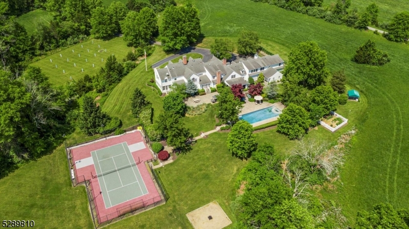 Welcome to Oakland Farm, a truly exceptional residence nestled on 13 plus farm assessed acres in beautiful "Bedminster Horse Country." The Oak Tree lined drive leads you to thisElegant and Expansive Estate, boasting 7 BRs and 8.2 baths. This property offers a rare blend of grandeur and tranquility.The chef's kitchen is a culinary masterpiece, featuring high-end appliances and an adjoining bakers kitchen perfect for creating sweet treats. An entertainer's delight featuring a formal LR and DR, sunken family room w/ built-ins and game room w/ brick FP, bar and wine fridge, or just retreat to the cozy sunroom for bird watching and beautiful sunsets.Perfect for multi-generational living, an elevator in the 4 car garage provides effortless access to a one bedroom apartment with full LR, DR and EIC. Plus plenty of extra space in the finished basement with a full bath.Embrace the outdoors- the slate patio off the covered Alfresco dining area has paver blocks leading to a hedge lined concrete pool and spa, pool house with kitchenette and full bath. Lush landscaping creates an oasis for relaxation and entertainment. There is a multi-use sports court great for tennis, basketball, pickleball and even ice skating in the winter! This thriving "Gentleman's Farm includes mixed alfalfa hay, apple and peach orchards, wild and perennial fruit patches, garden and endless opportunities, adding a bucolic charm to the property.