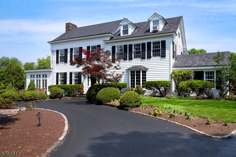 An elegant white 19th century Federal Style Home just 5 miles from Princeton stands on four acres with sweeping views of bountiful gardens, a picturesque pond and park-like lawns. Just passing by, it is clear that the current owners have been excellent stewards of this historic property. Even though the house was built with large rooms and high ceilings across all three floors, carefully considered expansions by acclaimed local architect Max Hayden have added still more space for entertaining, as well as the possibility of single-level living. French doors flanking the living room fireplace open to a glorious sunroom with a stone floor and a commanding stone fireplace. Off the celebration-sized dining room, the second addition serves as an office or a stunning guest suite. The eat-in kitchen has modern functionality with pro-level appliances and an open sightline into the family room, yet custom cherry cabinetry feels period-appropriate and a walk-in fireplace stands as a reminder of meals simmering all day over a constant flame. All have great closet space, especially the primary suite with a walk-in outside the cheerfully tiled bath. With a full kitchen and a clean white bathroom, the multi-room third floor serves equally well as a guest suite or a spot for all-day play and all-night sleepovers. Even the cupola capped garage beautifully supports the needs of a modern lifestyle with three bays, a workshop and solar panels.