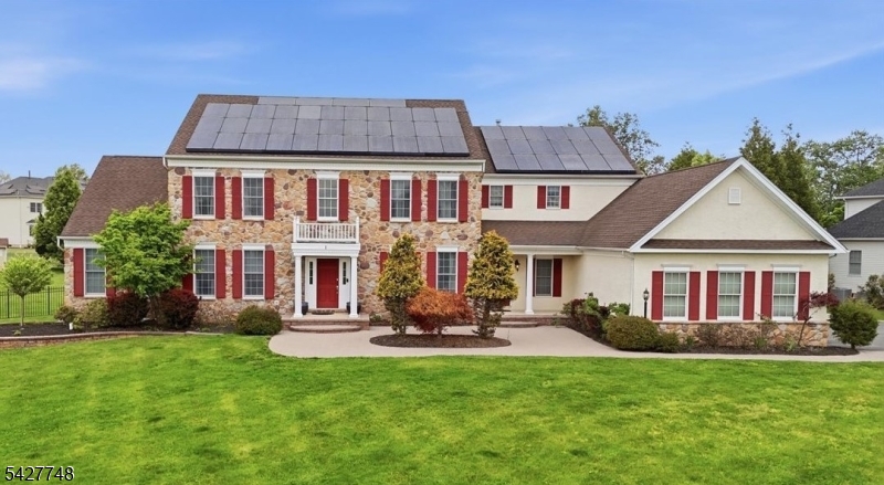 This exceptional Colonial home offers over 5,000 square feet of living space and is situated on approximately one acre of beautifully maintained property. The fully fenced yard provides privacy and includes an outdoor patio complete with a built-in grill ideal for entertaining. The main level welcomes you with an open floor plan and showcases hardwood flooring throughout. The large eat-in kitchen is equipped with stainless steel appliances, granite countertops, and an oversized center island. Additional first-floor features include a private office, conservatory, den, sunroom, great room w/gas fireplace, laundry room, powder room and formal dining room. The second level can be accessed by one of two staircases. It features a spacious primary suite with an additional sitting room, a luxurious en-suite bath and oversized walk-in closet. Three additional generously sized bedrooms each include their own full bath and WIC, offering comfort and convenience for all. The fully finished walk-out basement expands the living space and includes a home theater, exercise room, bar area, rec space and a full bathroom.. This home is connected to PUBLIC WATER and SEWER and has been recently updated with a new hot water heater. Energy-efficient solar panels provide added cost savings. Close to shopping/restaurants. Award winning blue ribbon school district!