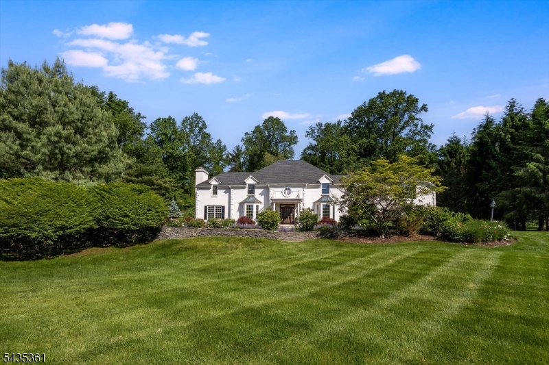 Perched on 2.5 acres backing MacGregor Preserve, a sweeping front lawn welcomes you via a winding driveway to this Chester gem. Inside, a soaring ceiling and striking floating staircase define the grand foyer.  A true open concept invites you in as the living room unfolds with quiet confidence and French doors lead to the library w/ wood cabinetry, built-ins & marble-adorned fireplace. Art anchors the design and infuses the architecture. The updated open kitchen offers a pantry and leads to casual dining & a great room w/ floor-to-ceiling views of the bluestone patio & lush backyard. Connected by a wet bar/butler's pantry, the formal DR accommodates a crowd. Completing the 1st floor is functional mudroom w/ laundry and a bonus space (currently used as a yoga studio) that is ideal for gym/guest/office/play. Hardwood floors throughout feel layered and harmonize perfectly with the home's distinguished and delightful character. The primary suite and sitting area with fireplace and custom built-ins is outfitted with 3 walk-in closets and a gorgeous marble spa-like bathroom: a private and luxurious retreat. Joined at one end by a back staircase to the kitchen, the catwalk hall overlooks below, leading to 4 large bedrooms & 3 baths, incl 2 ensuite bedrooms + 2 bathrooms in a private wing with a shared bath.  There is a 2nd laundry upstairs. Designed to be at once beautiful and livable, perfectly blending comfort and elegance, and just mins to historic Main St. & 40 mi to NYC.