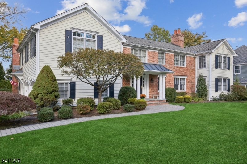 THIS IS THE ONE! Behind the historic stone wall on THE MADISON HILL, sits this stunning renovated center hall Colonial that has been meticulously updated and maintained, blending timeless craftsmanship, privacy, and modern sophistication just minutes from town, direct NYC train, and top-rated schools. Set on .44 acres, the home features hardwood floors, custom millwork, and oversized windows that fill every room with light. The formal living and dining rooms each showcase gorgeous floors and fireplaces. The spectacular kitchen w white custom cabinetry, center island, coffee bar, and desk area flows seamlessly into a vaulted Great Room w custom built-ins, spectacular windows and beautiful fireplace. A private office, cozy den and first-floor mudroom add convenience. Upstairs, five bedrooms and four baths include a luxurious primary suite with two oversized walk-in closets, a window seat, and spa-like bath. Second-floor laundry adds effortless daily convenience.The finished lower level is a dream with gym space, lg rec room, and media rm for gaming and movie nights. Large windows and full bath offer potential for an additional bedroom. Step outside to the covered back porch overlooking the private yard, patios and lovely gardens. Oversized two-car garage and gas generator completes this exceptional home. Don't miss this rare opportunity to live in this sought-after neighborhood near Triangle Park, just minutes from downtown Madison, voted the #1 town to live in NJ (NJ Monthly).