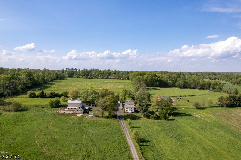 89 acres roll out like a pastoral dream - this is not your average farmstead. This is a place where traditions are honored, animals are well-housed, and there's a proper barn just for parties complete with a barrel-vaulted ceiling and a bar. Featuring fenced paddocks, dry lots, and barns that still serve their original purpose: 4 stall horse barn with heated tack room, a hayloft that swallows up to 1,200 bales, dairy barn brimming with potential, and a proper chicken coop. At the center, the 19th-century farmhouse has been added upon and transformed - warmed by two grand gas fireplaces. The kitchen, with its oversized island, hearth, and casual dining nook, is where the hours melt away. The great room, with its soaring ceiling and shuttered interior windows, is equal parts music hall and quiet escape. The living room spills out onto a wide bluestone patio. The dining room still knows how to host a holiday, and the upstairs main bedroom is thoughtfully tucked away from the others, one of which hides a cedar closet. There's laundry upstairs, a sauna below, and a stone-walled nook that all but begs to become a wine cellar. Elsewhere on the property are surprises that stretch this estate beyond a single narrative: a garage with a finished game room above, a storybook cottage-style apartment, another two-bedroom apartment with a loft, and a studio with its own bathroom. In a world that moves too fast, this is a place that knows how to slow down while keeping farm life humming.