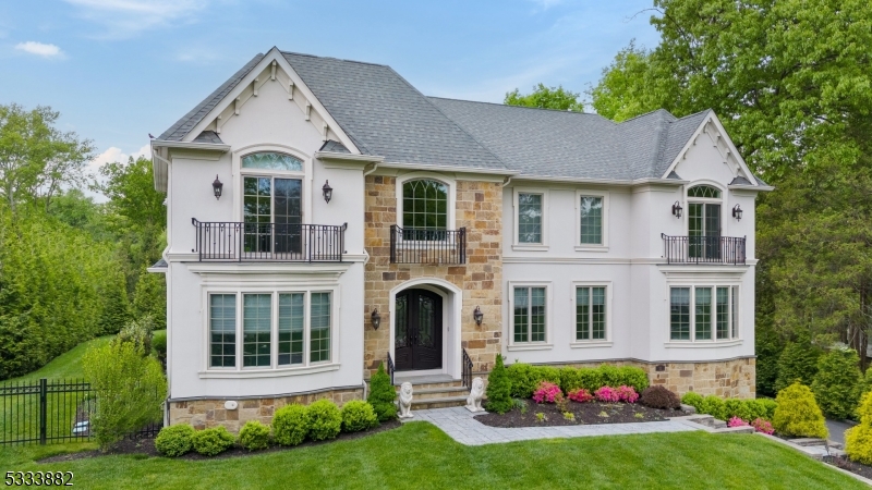 Nestled in the scenic Hartshorn section of Short Hills, this 2018 bespoke 7 bedroom residence emerges as a beacon of luxury and architectural elegance. Welcome to a departure from the ordinary and a journey into high design where every single detail, from a sophisticated color palette to striking wall textures to exquisite designer finishes, was meticulously selected to perfection. Those at the pinnacle of success will appreciate the grand spaces yet peace and solitude offered by this remarkable and exceptionally refined home. The first level is highlighted by a soaring entry foyer, two bedrooms/offices, a chef-inspired dream kitchen that seamlessly transitions into a magnificent family room, and direct access to the sumptuous backyard. Upstairs, four ensuite bedrooms include a resplendent primary suite, with vaulted ceiling, cozy gas fireplace, two custom boutique-inspired dressing rooms and luxurious spa-like bath with heated floors. The lower level is just as impressive, with a bedroom suite, recreation room, inspiring exercise room and exhilarating home theater. Outside, an expansive patio with motorized awning sets the stage for al fresco entertaining, overlooking a spectacular heated saltwater pool and picturesque flat lawn with lush specimen plantings, inviting tranquility and outdoor fun.  For those with discerning taste who only surround themselves with the very best, live the lifestyle you have always dreamed of, all uninterrupted via a built-in home generator.