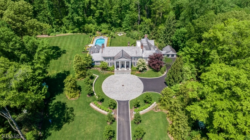 Welcome to this remarkable custom built 6 bedroom colonial sitting on over 4 acres down a private road in Harding. This sophisticated yet inviting home offers exquisite entertaining areas as well as comfortable rooms for everyday enjoyment. A grand two story foyer, front to back living room, banquet-sized dining room, coffered ceiling library, sitting room, breakfast room, large family room and a chef's kitchen featuring a gas fireplace and dual islands make this first floor spectacular. Personal space abounds upstairs with 6 beds and 4 full baths. The primary bedroom includes a luxurious bath, sitting room and balcony overlooking the park-like grounds. An already generous floor plan is increased by the extensive lower level offering a custom lodge-style recreation room with bar and fireplace, gym, bright and spacious playroom, workroom, wine room and so much more. The open and level backyard is ideal for entertaining with a heated pool, outdoor kitchen, built-in fire pit, blue stone patio and a 3 season sunroom. Not to be missed is the brand new separate home office providing a private space to work with ample  built-ins and it's own entrance.