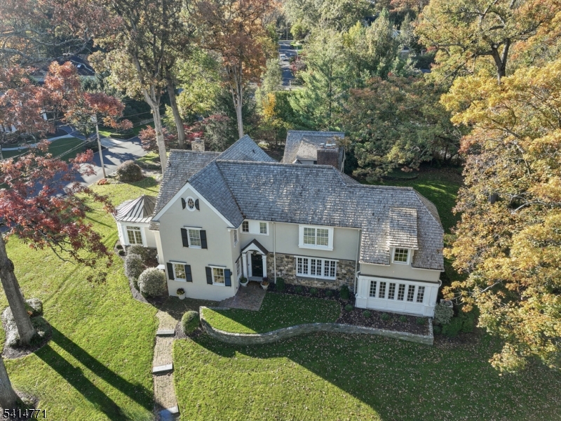 SIGNIFICANT PRICE ADJUSTMENT ON THIS STUNNING RENOVATED ESTATE IN A PRIME NORTHSIDE SUMMIT LOCATION. Welcome to 55 Oxbow Lane, a 6BR, 5.2BA French Colonial sitting on.75 acres in Summit's coveted Northside. A gracious foyer w/9 ft. ceilings, arched openings, custom millwork, leaded glass, & hardwood floors sets a refined tone. The LR w/fireplace flows into a fab sunroom. Across the foyer, a formal DR leads to the renovated kitchen w/heated floors, quartz counters, center island & high-end appliances - Bosch, Viking, SubZero, Rohl & Miele - plus a walk-in pantry w/wine fridge & built-in espresso machine. The inviting FR features cherry wood paneling, built-in bookshelves & fireplace. A renovated powder room, mudroom & attached 2-car garage complete the main level. Upstairs find 6 spacious BR's & 5 renovated baths. The primary suite BOAsts a spa-like bath w/heated floors, dual vanities, Rohl faucets, soaking tub & steam shower. Each bedroom features ample light & custom closets. The finished basement has a media room, rec room study zone, renovated laundry & half bath. Outside, enjoy a stunning bluestone patio & a private, fully fenced yard w/open lawns, perfect for play, relaxation & gardening. The property BOAsts magnificent specimen trees and countless flower beds. Located just blocks from Summit's vibrant downtown, top-rated schools (Lincoln-Hubbard Elementary School) & the Midtown direct train to NYC, 55 Oxbow Lane perfectly blends luxury, location & lifestyle.