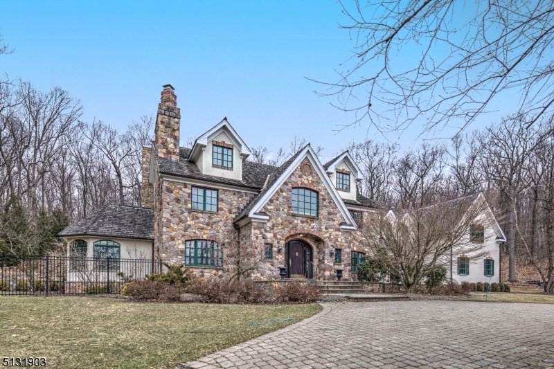COUNTRY RETREAT! A tree lined approach and circular drive lead to this stone and stucco home with a European flair. The most discerning buyer will appreciate the quality and attention to detail throughout. It is a showcase for exquisite moldings, exceptional millwork and unique floor and ceiling designs. A handsome home office and sun filled conservatory add to the enjoyment of living in this custom home. The elegant 2nd floor main bedroom suite offers a fireplace, luxurious bath & large twin fitted closets. Four additional bedrooms, one on the first floor, plus 4 full and two half baths provide room for all. Most rooms offer several large spaces for gathering including the great room adjacent to the-state-of-the-art kitchen with large center island, turreted breakfast room, and features every chef will enjoy such as the 8 burner Viking range with pot filler. The 3rd level features a carpeted bonus room while the lower entertainment level offers a large game room, theater room with tiered seating, as well as separate spaces for work & hobbies. Dog lovers will appreciate the convenient canine bathing & grooming area near the 4 car garage with car lift. Outdoor amenities in the fenced rear yard include a large patio with fireplace & chimney plus heated pool with elaborate waterfall feature. Love the location of this 4.8 acre setting surrounded by Nature yet convenient to transportation modes, schools, & quaint towns. A rare treat! SF from town doesn't include finished basement.