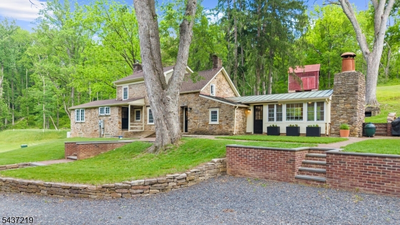 Steeped in history and beautifully reimagined for modern living, this circa 1797 stone home, formerly known as the Slack Holcombe House, offers a rare opportunity to own a truly special property. Thoughtfully restored in 2023, this historic residence blends timeless character with modern convenience on nearly 11 enchanting acres featuring a pond, creek, and serene surroundings. Offering 3 bedrooms and 2.5 baths, the home showcases authentic period details including wide plank flooring, three fireplaces, and carefully preserved architectural elements. Extensive updates include all new windows, bathrooms, electrical systems, roof, and septic all completed in 2023.The inviting kitchen features soapstone countertops and a Viking stove and opens to warm, welcoming living spaces designed for everyday living and entertaining. A spacious gathering room and formal dining room with stone fireplace and insert enhance the home's rich character. Outdoor living is equally impressive with an expansive brick patio overlooking the picturesque setting. Additional structures include a detached two-car garage with studio/guest quarters featuring a full bath and a charming bank barn ideal for a workshop, studio, or hobby space. Architectural plans are available for a future two-story addition including a second-floor primary suite. Historic charm, fully upgraded for modern convenience. Pool and Bank Barn conveyed in As-Is Condition